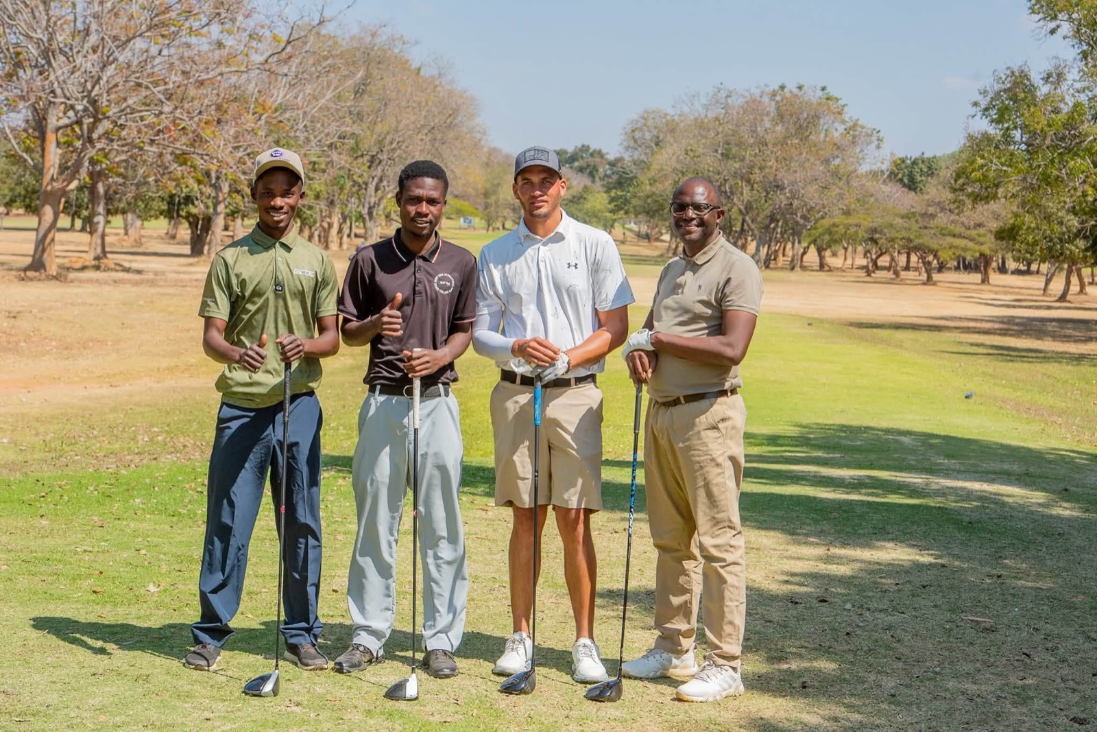 Four players standing together on the fairway with their clubs