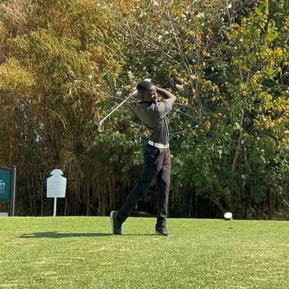 A group on the tee box with trolleys and bags